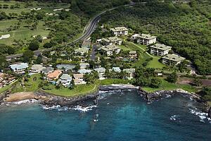 Aerial of houses clustered by Maui, Hawaii coast.