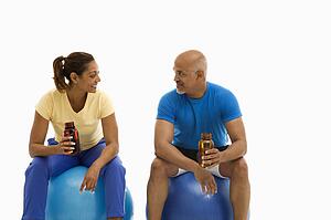 Man and woman sitting on blue exercise balls