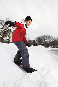 Boy snowboarding in snow