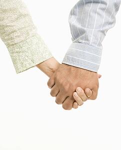 Close up of woman and man holding hands.