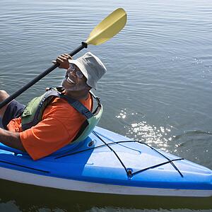 African American middle-aged man smiling at viewer in kayak.