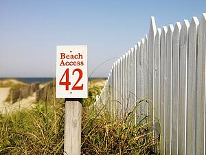 Beach access sign with picket fence at Bald Head Island, North Carolina.