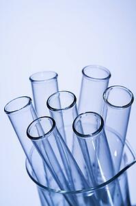 Test tubes in glass beaker with blue tint.