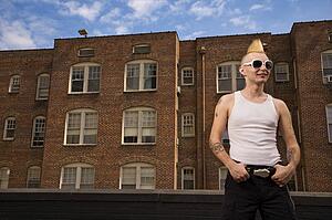 Portrait of a male punk standing in front of a building