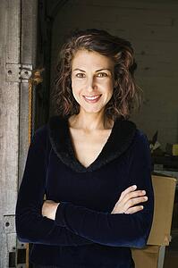 Portrait of pretty woman standing with arms crossed smiling