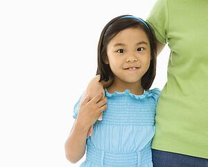 Mother and daughter standing with arms around each other