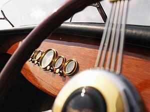 Detail of wooden boat with steering wheel and dashboard. 