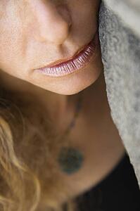 Close up of Caucasian female with face leaning against rock.