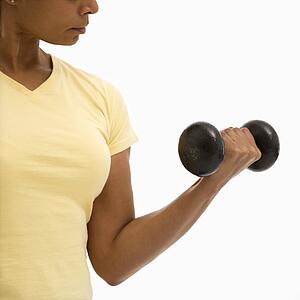 Woman doing arm curls looking at bicep