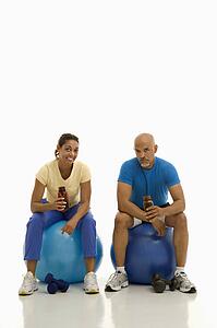 Man and woman sitting on blue exercise balls