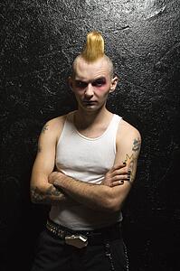 Portrait of mid-adult male punk with arms crossed