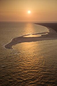 Aerial view of sun over Atlantic ocean and shoreline of Bald Head Island, North Carolina