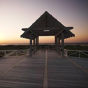 Gazebo at North Carolina coast with setting sun in background.
