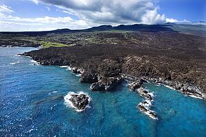 Aerial of Pacific ocean and Maui, Hawaii coast with lava rocks