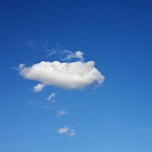 Single fluffy cloud in blue sky.