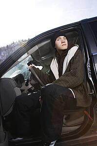Caucasian male teenager sitting in SUV looking at viewer. 