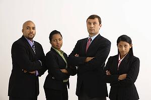 Portrait of businessmen and businesswomen standing with arms crossed looking serious