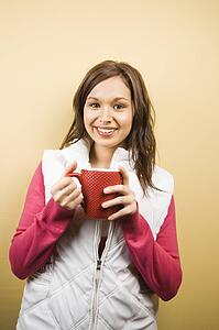 Woman holding coffee cup and smiling 