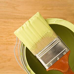 High angle view of paintbrush resting on paint can