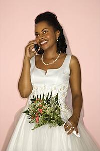 Bride talking on cellphone on pink background