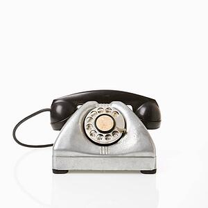 Rotary telephone with black receiver.