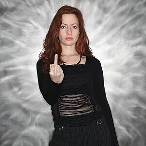 Portrait of pretty young redhead woman giving middle finger gesture.