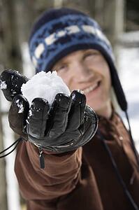 Man holding snowball out towards viewer.