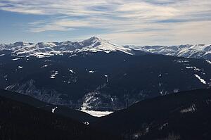 Snow covered mountain peaks with valley in Colorado.