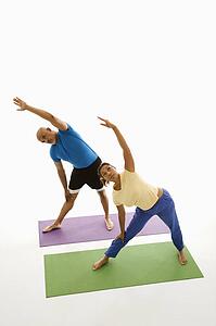 Man and woman standing on exercise mats