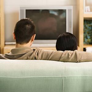 Couple sitting on couch watching TV