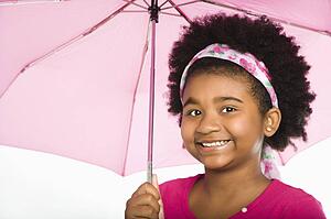 Girl holding pink umbrella smiling