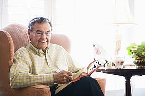Man sitting in chair reading a book