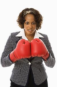 Businesswoman wearing boxing gloves looking serious