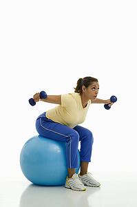 Woman balancing on blue exercise ball 