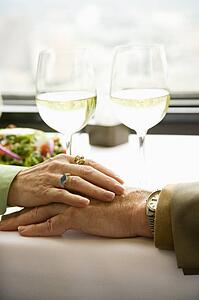 Couple at table holding hands