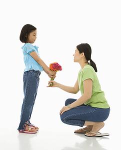 Girl handing bouquet of flowers to her mother