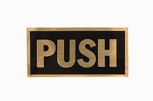 Push sign with gold text against white background.