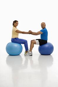Man and woman balancing on exercise balls 