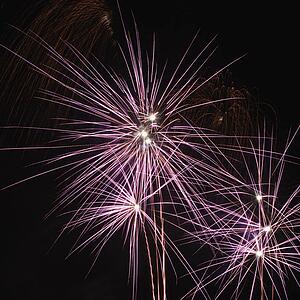 Colorful fireworks exploding in night sky.