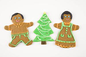 Sugar cookie Christmas tree between gingerbread male and female.