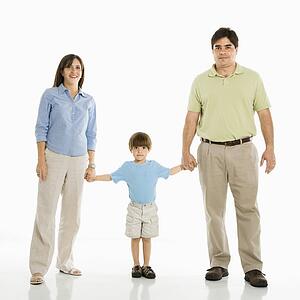 Family of three standing holding hands