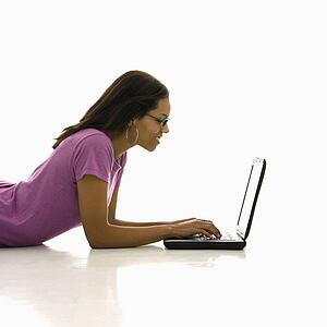 Woman lying on floor using laptop