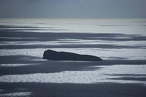 Large rock island in Pacific ocean.