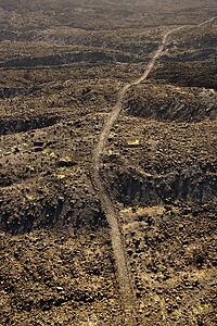 Aerial view of trail through lava rock filled terrain in Maui, Hawaii.