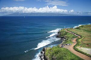 Aerial view of coastline with surfers and parked cars on Maui, Hawaii 
