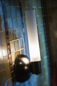 Interior shot of tile wall with lamp.