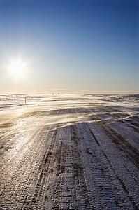 Ice covered road with tire tracks.