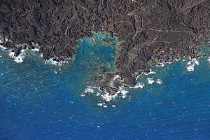 Aerial of Pacific ocean and Maui, Hawaii coast with lava rocks.