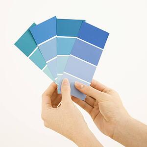 Hands holding paint color swatches