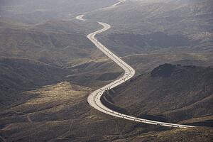 Aerial of Route 14 with traveling vehicles through rural California landscape